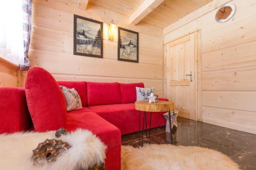 a living room with a red couch and a table at Domki u Magdy in Zakopane