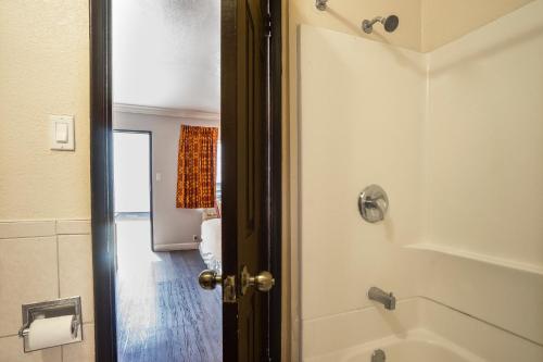 bagno con doccia e porta aperta di Value Inn Hollywood a Los Angeles