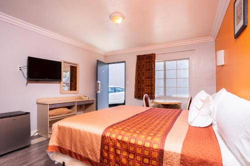 una camera d'albergo con letto e scrivania di Value Inn Hollywood a Los Angeles