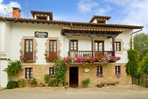 a building with flowers on the side of it at Posada Revolgo in Santillana del Mar