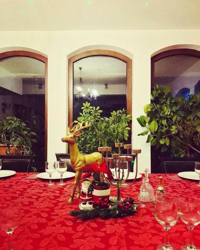 a table with a statue of a deer on a red table cloth at Pension Casa Vanatorilor in Băile Olăneşti