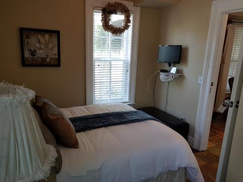 a bedroom with a bed with a wreath on the window at Hellemsfield Inn & bed and breakfast in Kingsville