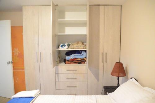 a bedroom with a white closet with a bed at VFC Suites Cuenca - Ecuador in Cuenca
