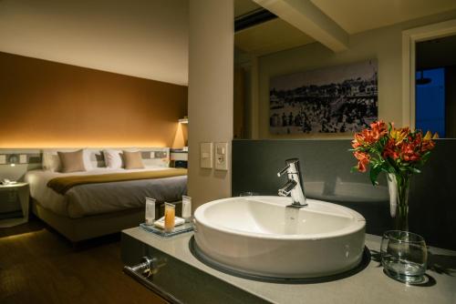 蒙特維多的住宿－歐文蒙得維的亞酒店，一间带水槽的浴室和一间带一张床的卧室