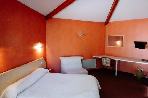 a bedroom with a bed and a desk and a sink at Logis Hotels - Hotel Restaurant l Enclos in Donneville