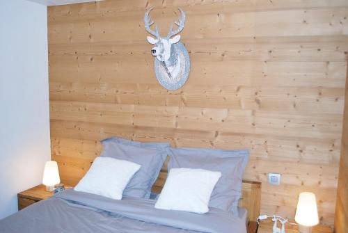 Dormitorio con cama con cabeza de ciervo en la pared en Appartement 25m2 à Saint-Gervais les bains, en Saint-Gervais-les-Bains