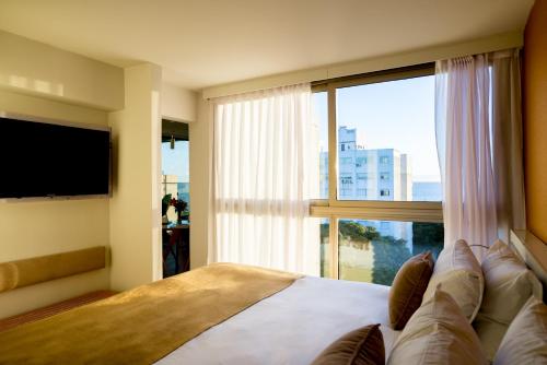 1 dormitorio con 1 cama y ventana grande en Own Montevideo en Montevideo