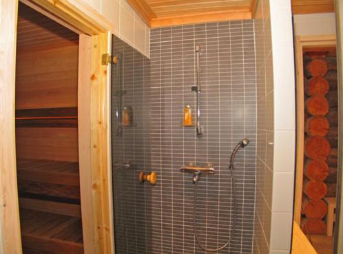 a bathroom with a shower with blue tiles at Kelokoto Chalets in Ruka