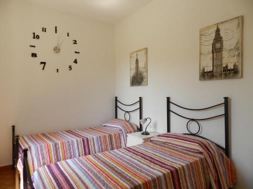 sypialnia z 2 łóżkami i zegarem na ścianie w obiekcie Appartamento S. Valentino w mieście Terni