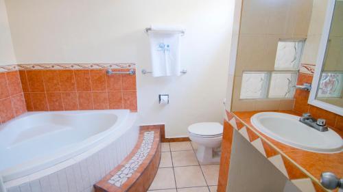 a bathroom with a tub and a toilet and a sink at Hotel Tepic in Tepic
