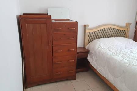 a bedroom with a wooden dresser next to a bed at Contry La Silla Apartments zona tec - Nuevo Sur in Monterrey