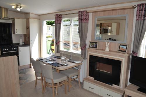 a dining room with a table and a fireplace at The Balmoral Caravan in Dornoch