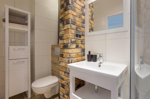 une salle de bain avec un lavabo blanc et des toilettes dans l'établissement Mariacka1, à Szczecin