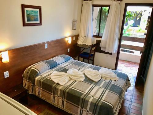 ein Schlafzimmer mit einem Bett mit zwei Handtüchern darauf in der Unterkunft Pousada Icaraí in Ilha Comprida