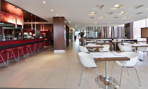 a restaurant with white chairs and tables and a bar at Best Western Hotel Goldenmile Milan in Trezzano sul Naviglio