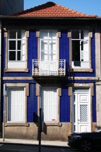 a blue building with a white door and a balcony at Ndussole Guest House in Porto