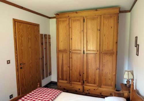 a bedroom with a large wooden cabinet and a bed at Apartments Casa Metz in Santa Cristina Gherdëina