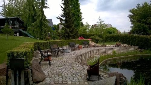 a stone walkway with chairs and a pond at Schluchthäusl in Lunzenau