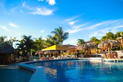 a pool at a resort with chairs and umbrellas at Apart Hotel Acuarious de Luis in Estelí