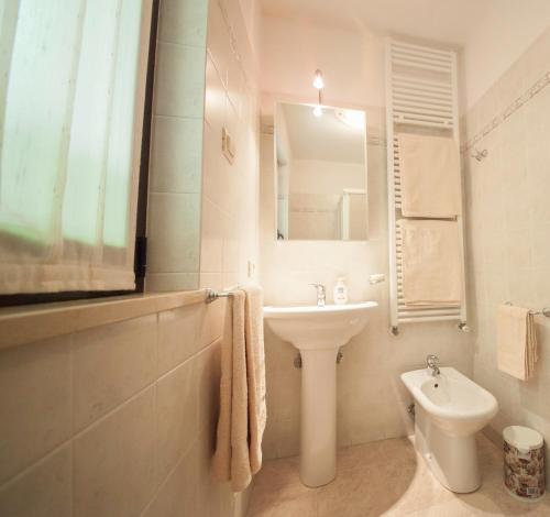 La salle de bains est pourvue d'un lavabo, de toilettes et d'un miroir. dans l'établissement Villetta maison hélène, à Aoste