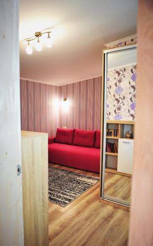 a living room with a red couch and a mirror at Apartment Sea Breeze in Fontanka