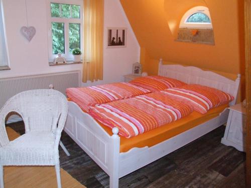 a bedroom with a bed and a chair at Schluchthäusl in Lunzenau