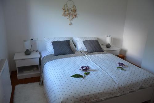 sypialnia z łóżkiem z dwoma kwiatami w obiekcie Grandma's House w Bledzie