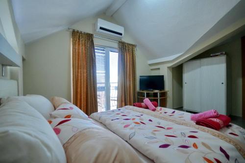 a bedroom with two beds and a large window at Vila Tea Petrusevski in Ohrid