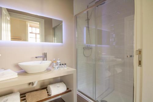 a bathroom with a glass shower and a sink at Gil Vicente - Charming Guesthouse in Porto