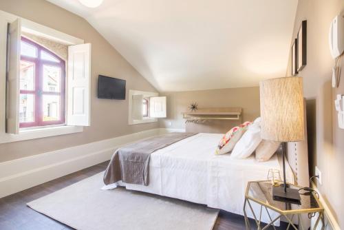 a bedroom with a large white bed and a window at Gil Vicente - Charming Guesthouse in Porto