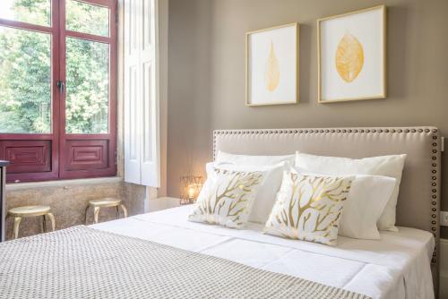 a bedroom with a white bed with two stools at Gil Vicente - Charming Guesthouse in Porto