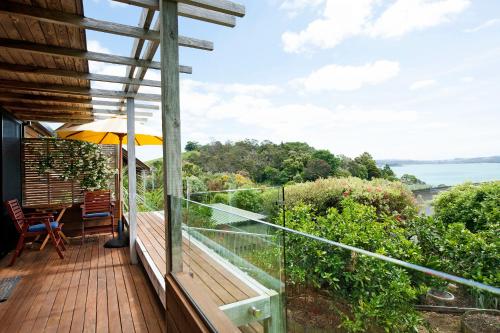 a balcony with an umbrella and a table and chairs at Te Manaaki Villa in Russell