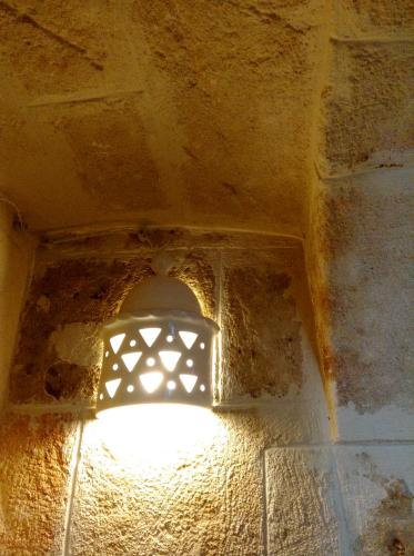 a light that is on the side of a building at La Torre e il Mare Rooms by STHEY in Monopoli