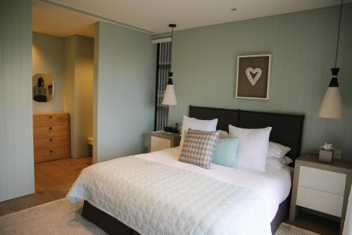 a bedroom with a large bed with white sheets and pillows at Kinloch Manor & Villas in Kinloch