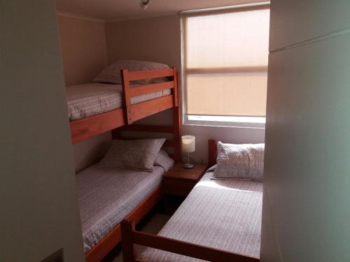two bunk beds in a small room with a window at Departamento en La Serena in La Serena