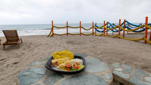 a plate of food sitting on the beach at Praba Hostel in Palomino