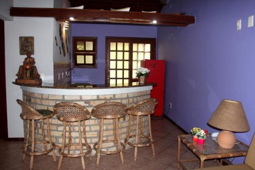 a bar with a group of chairs and a table at Chalés Saint Germain in Florianópolis