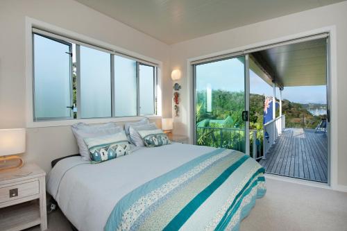 a bedroom with a large bed and a balcony at The Black Bach in Russell