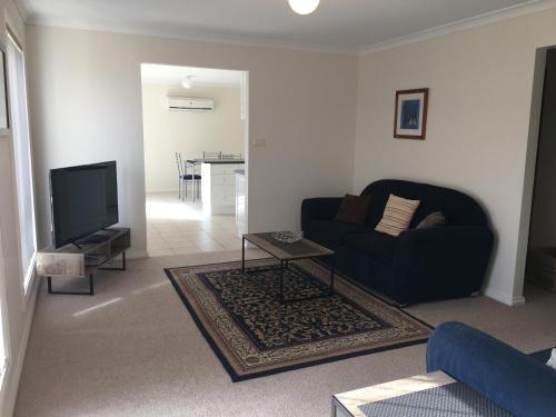 a living room with a couch and a tv at Melton Apartments in Melton