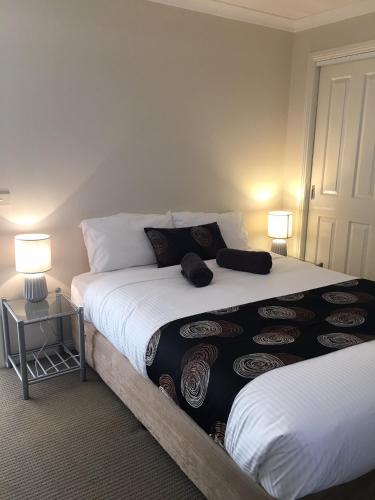 a bedroom with two beds and two lamps at Melton Apartments in Melton