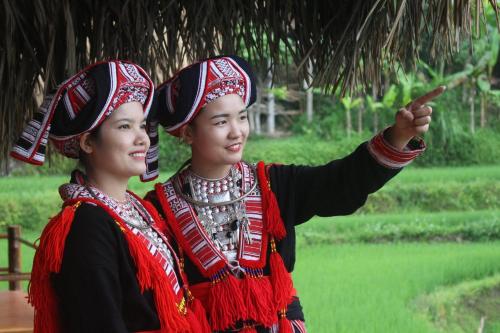 two women in traditional clothing standing next to each other at Hoang Su Phi Lodge in Ha Giang