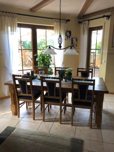 a dining room with a wooden table and chairs at Pension Pung in Herresbach