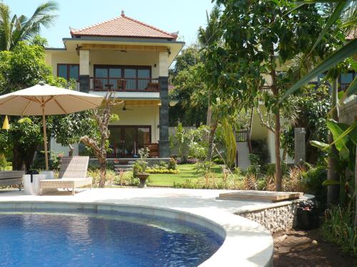 una casa con piscina e ombrellone di Sukun Babonsay Villas ad Amed