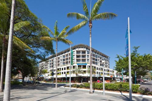 a building with two palm trees in front of it at Mantra Esplanade in Cairns