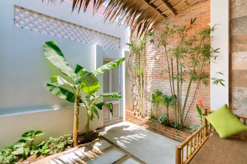 a room with a window with plants and a chair at Seamist Ocean Villa in Hoi An