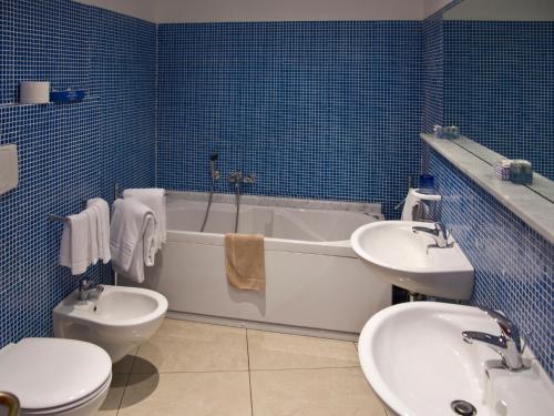 a bathroom with a toilet and a tub and a sink at Hotel Cristallo in Lerici
