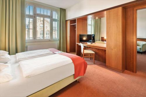 a hotel room with a bed and a desk at Best Western Plus Hotel Excelsior in Erfurt