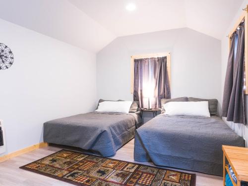 a bedroom with two beds and a window at Cache Cabins in Sunshine