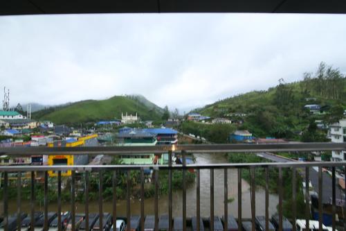 a view of a city with a river and buildings at Jays Inn in Munnar