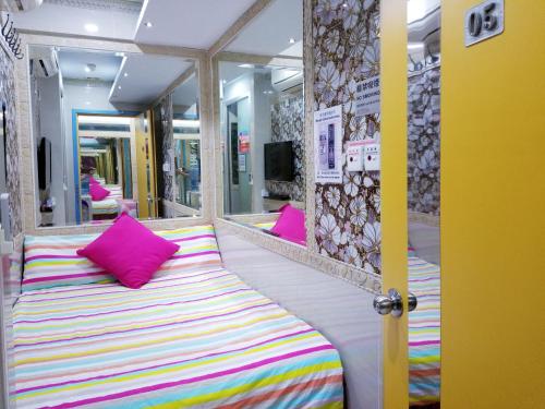 un sofá con almohadas coloridas sentado en una habitación en LongWin Hostel, en Hong Kong